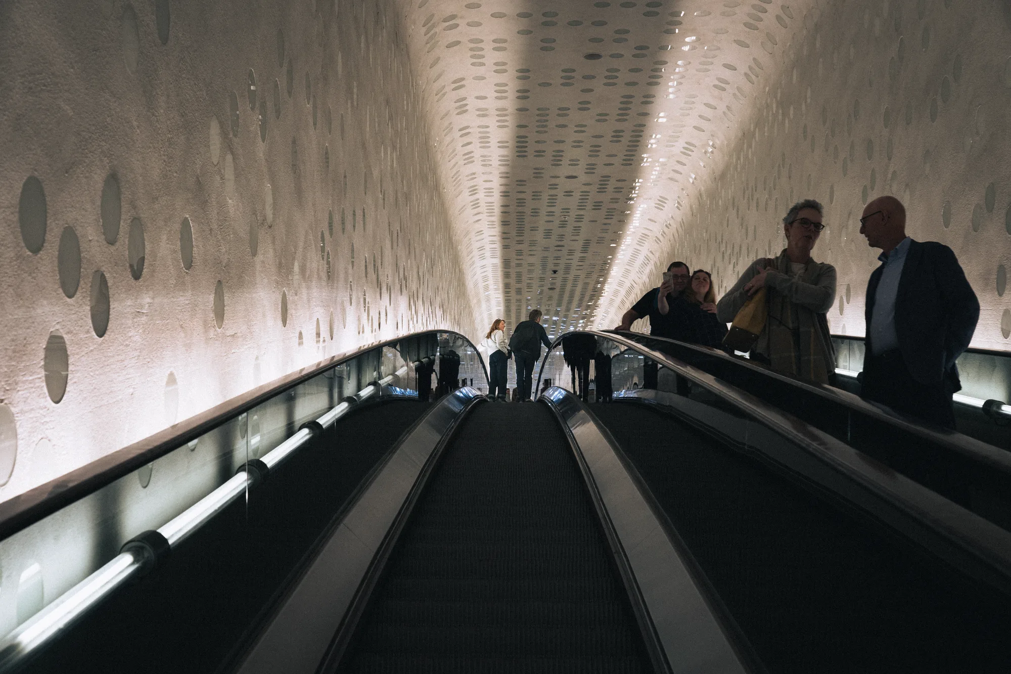 People riding the long curved escalator inside the Elbphilharmonie