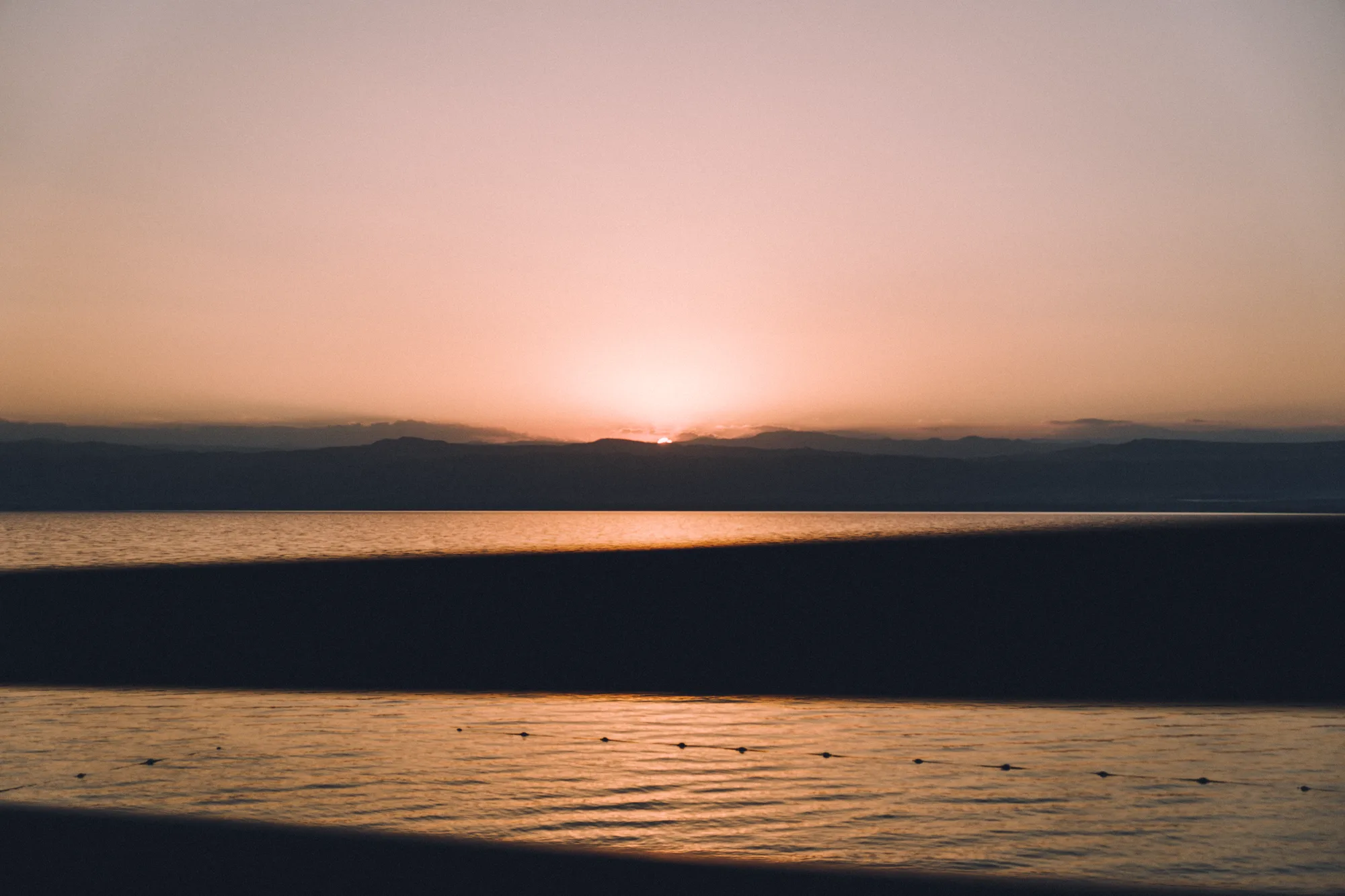 The sun setting behind the hills across the Dead Sea