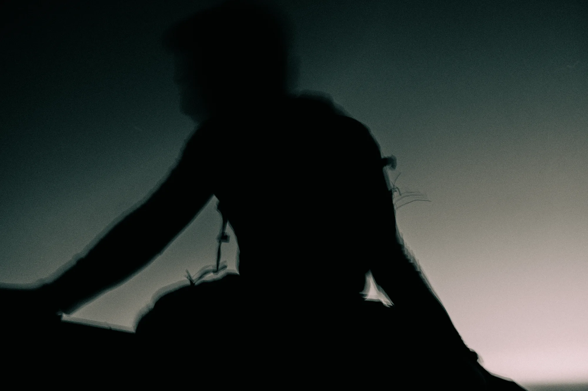 A blurred figure in silhouette against the evening sky