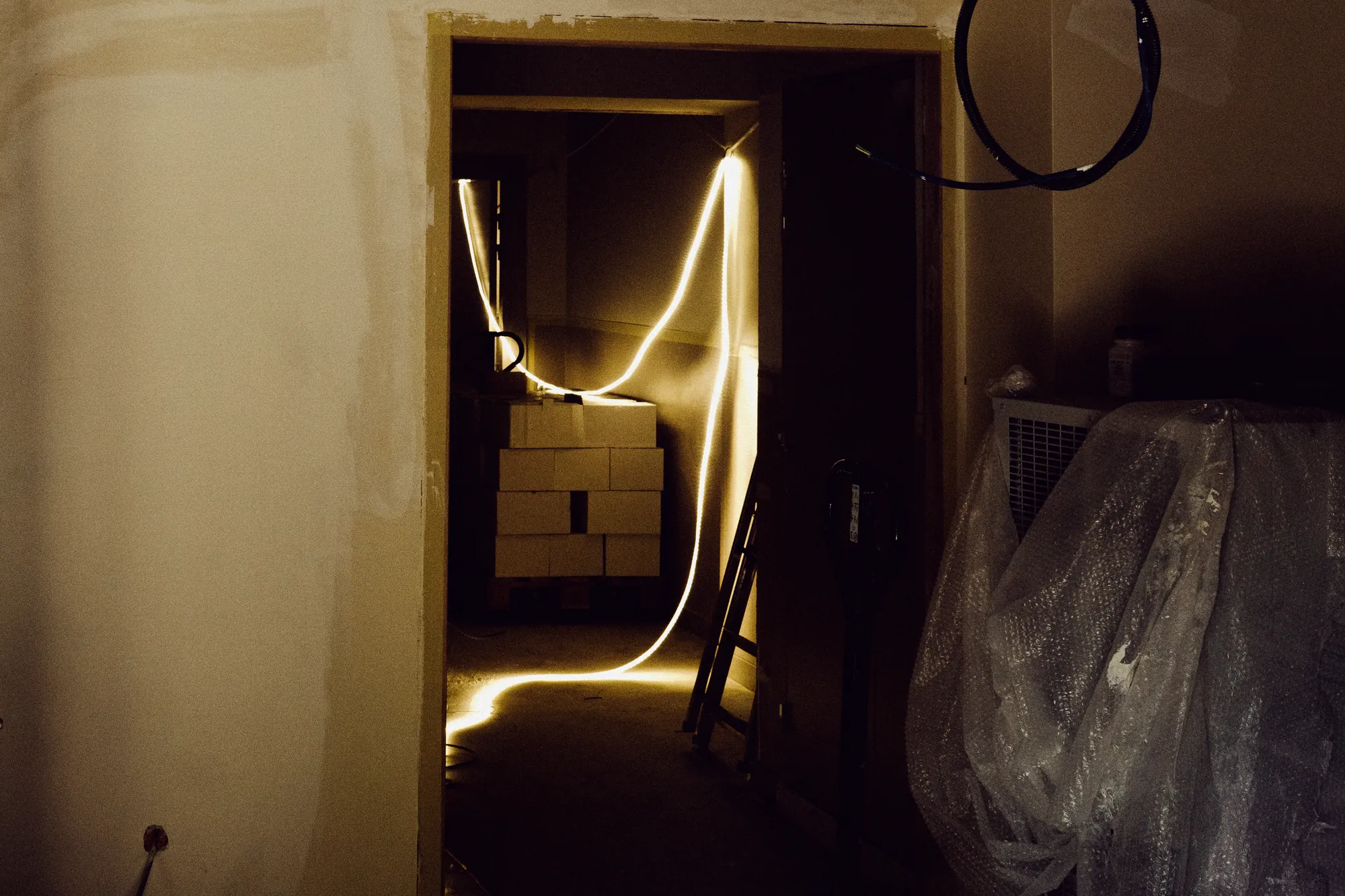 A strip of warm light running through a dark doorway